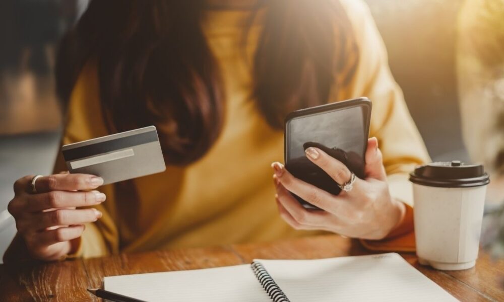 Pessoa organizando finanças com aplicativos e ferramentas digitais para controlar gastos e sair das dívidas.